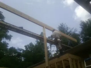Carpenter setting a ridge beam over a new addition frame — Ice Dam Removal by Roofing Brothers in Champaign