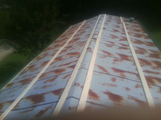 Rusted metal roof panels with new wood purlins before replacement — Storm Damage Roof Repair in Champaign by Roofing Brothers