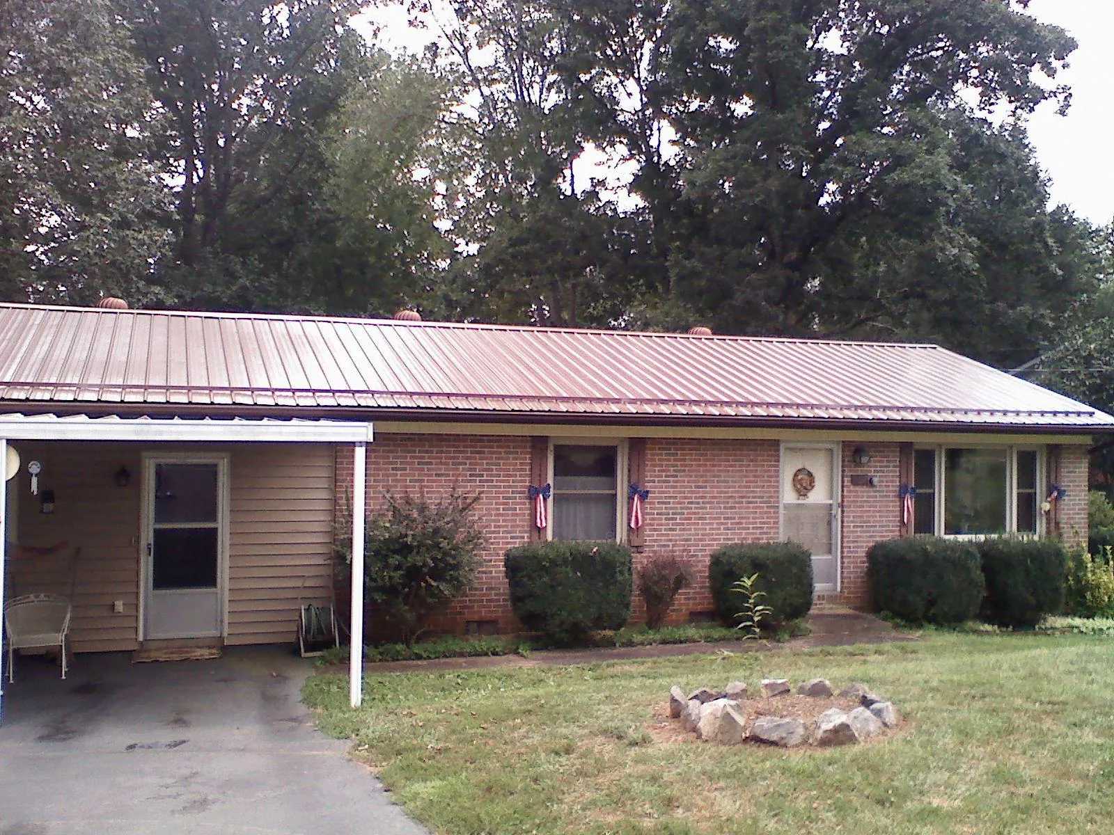Bronze metal roof and carport on a brick ranch home — Roof Repair work by our crew in Champaign